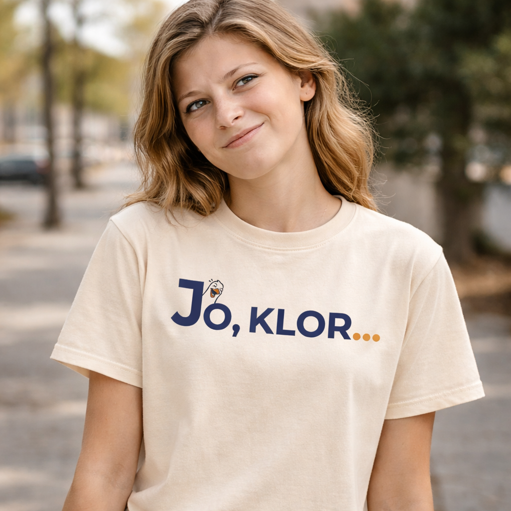 Junges Mädchen trägt das naturfarbene T-Shirt mit Aufschrift " Jo,klor..." und einer lachenden Möwe.