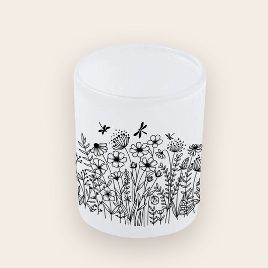 Satinierter Teelichthalter aus Glas mit schwarzen Wildblumen-Silhouetten.