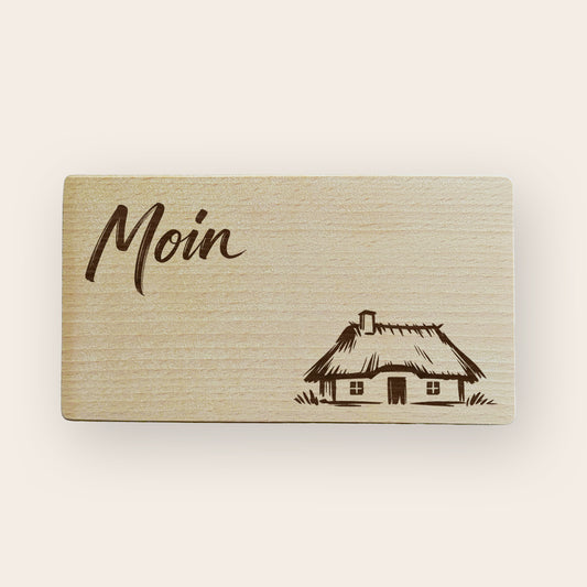 Frühstücksbrettchen aus Holz mit detaillierter Gravur einer norddeutschen Reetdachkate.