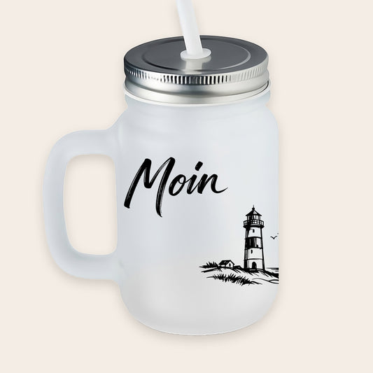 Satiniertes, matt-weißes Trinkglas mit Henkel, Metalldeckel und weißem Strohhalm, bedruckt mit schwarzem Leuchtturm-Motiv und dem Schriftzug „Moin“.