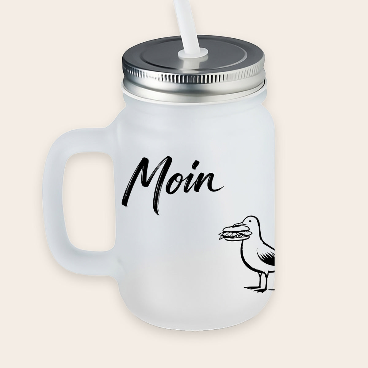 Satiniertes, matt-weißes Trinkglas mit Henkel und Metalldeckel, bedruckt mit einer Möwe, die ein Fischbrötchen im Schnabel hält, und dem Schriftzug „Moin“.