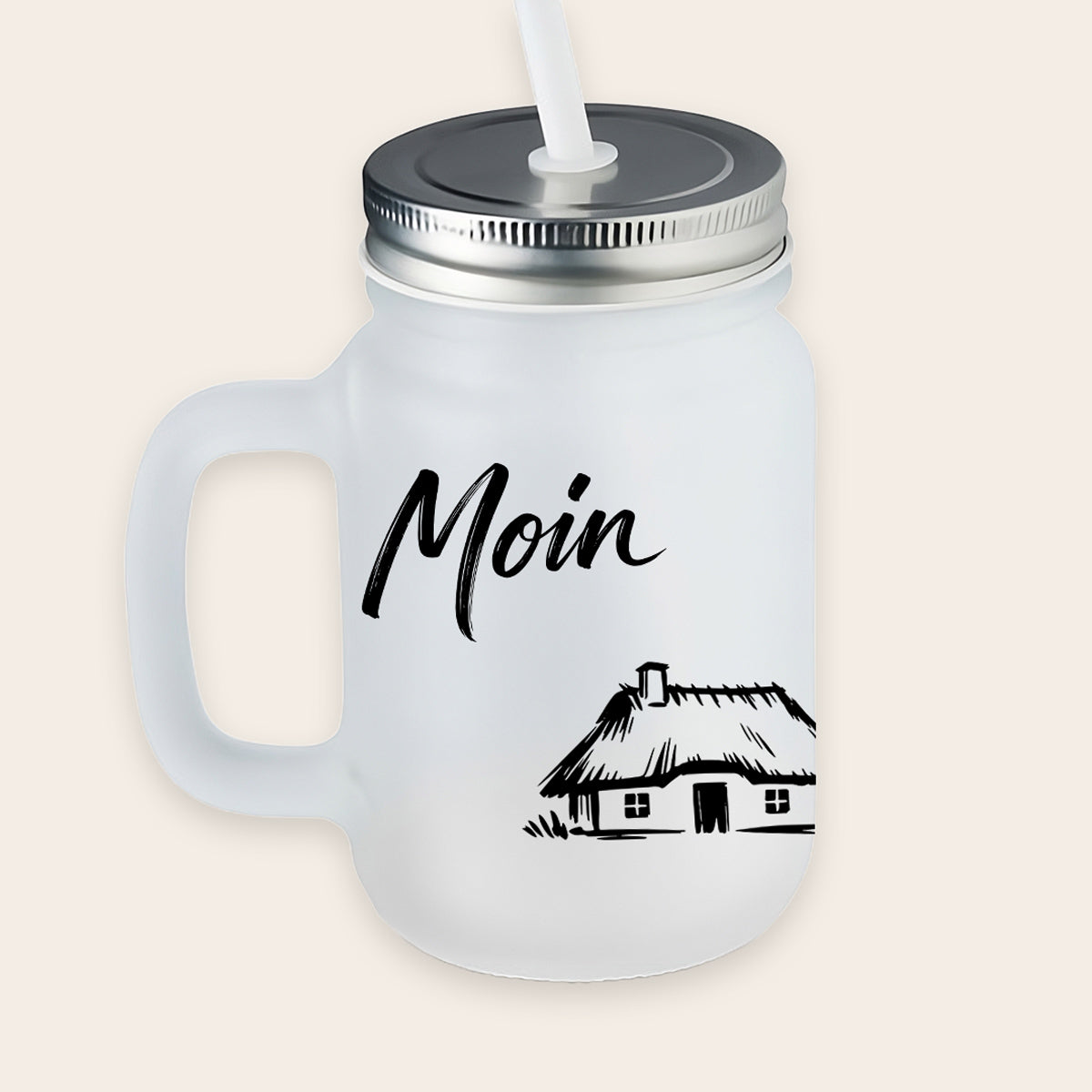 Satiniertes, matt-weißes Trinkglas mit Henkel, Metalldeckel und weißem Strohhalm, bedruckt mit einem schwarzen Reetdachhaus-Motiv und dem Schriftzug „Moin“.